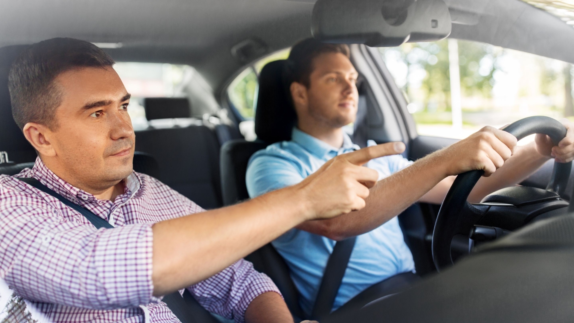 person driving car and instructor giving instruction