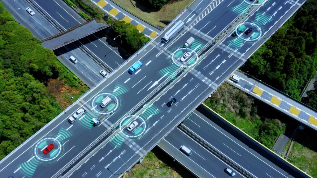 Aerial view of highway with smart car technology graphics.