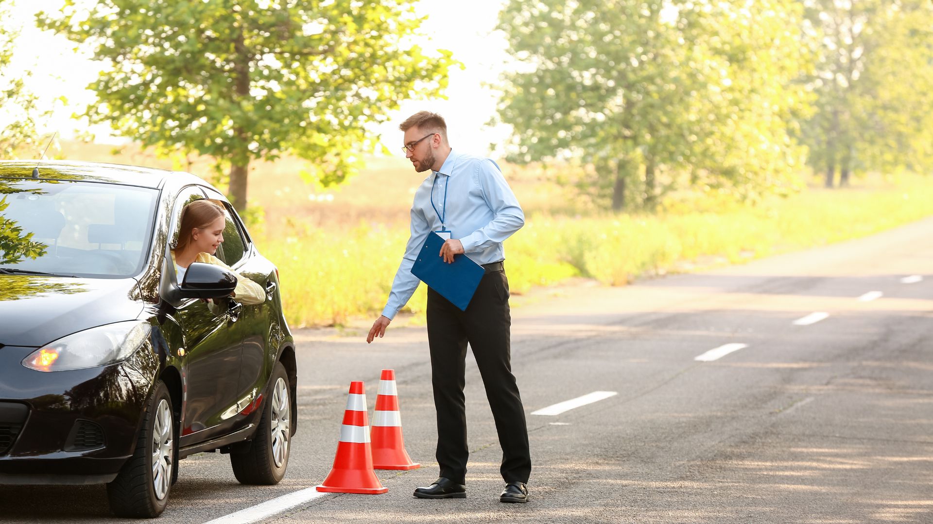 Driving instructor giving test to young female driver.