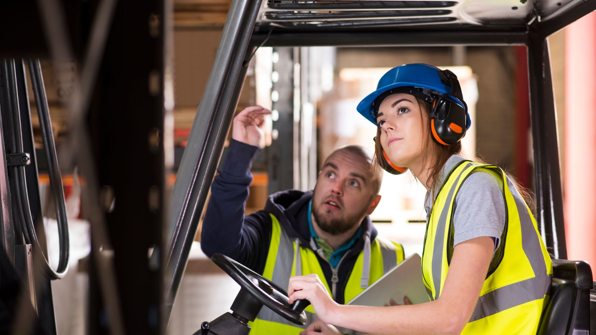 Forklift training session in warehouse with instructors.