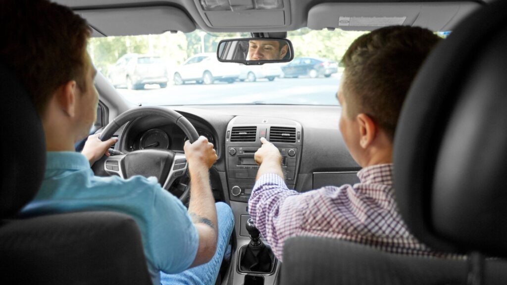 driving school person driving and instructor giving instruction