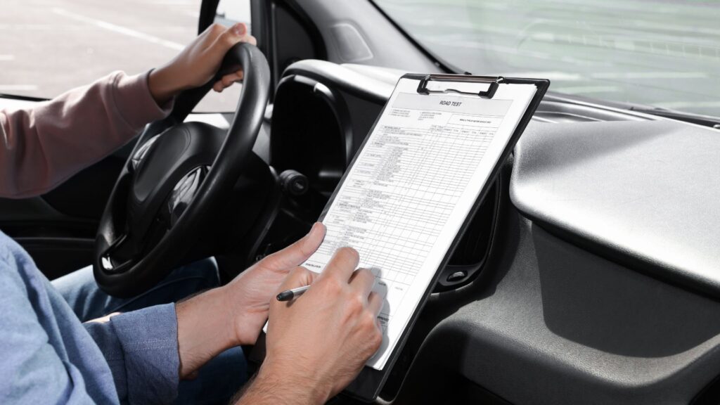 Instructor reviewing clipboard during driving test.