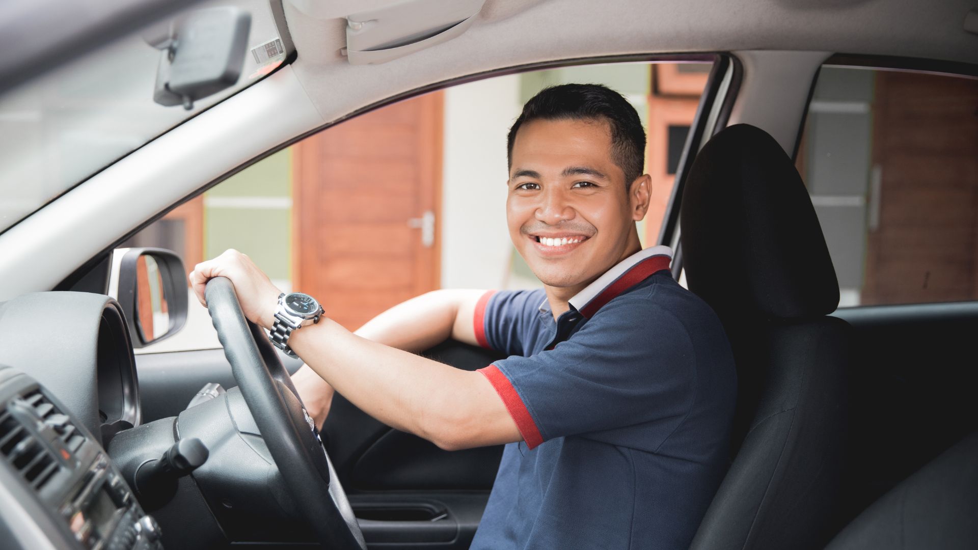 Smiling man driving car confidently