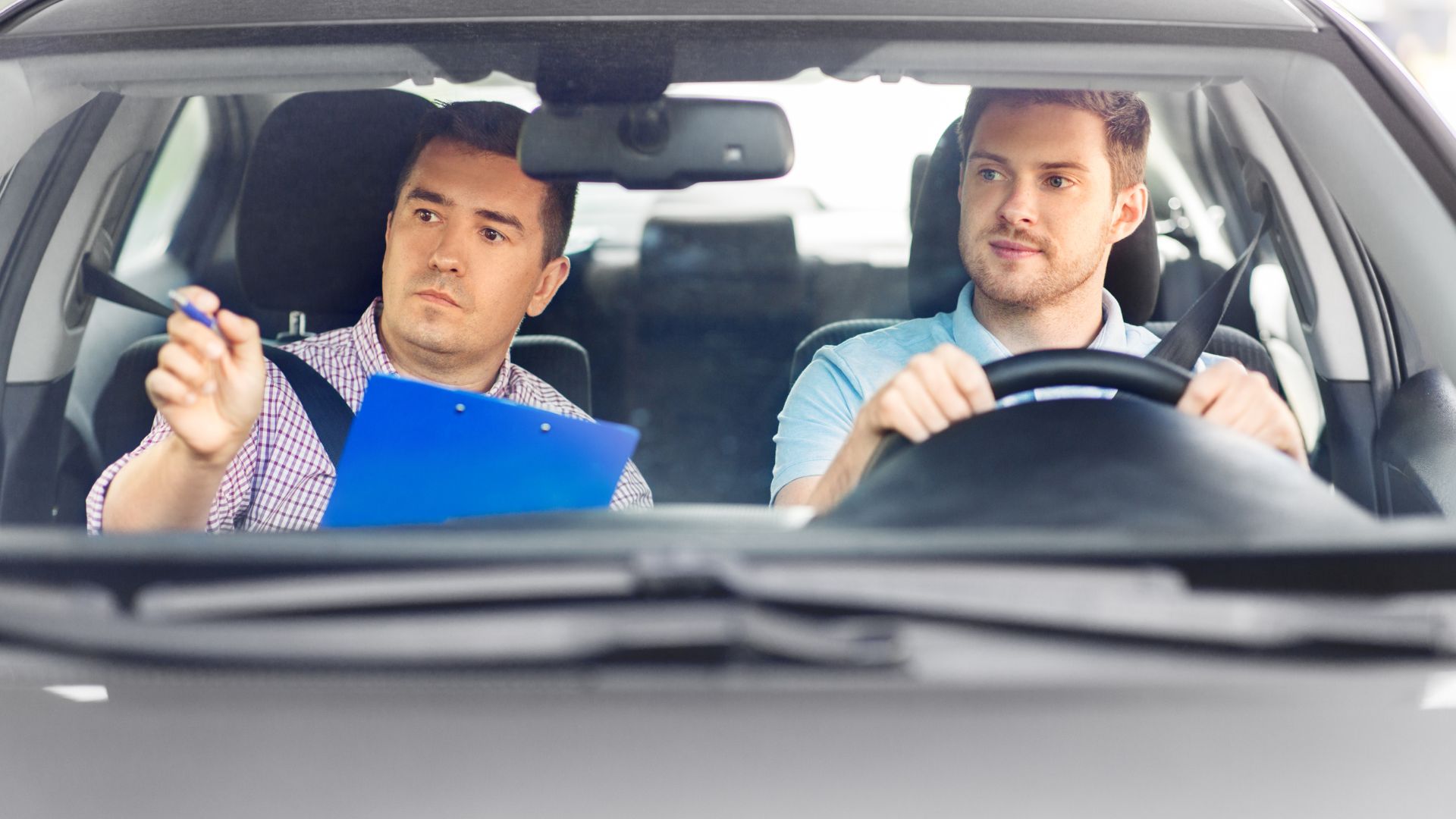 a person learning to drive a car and instructor giving instructions