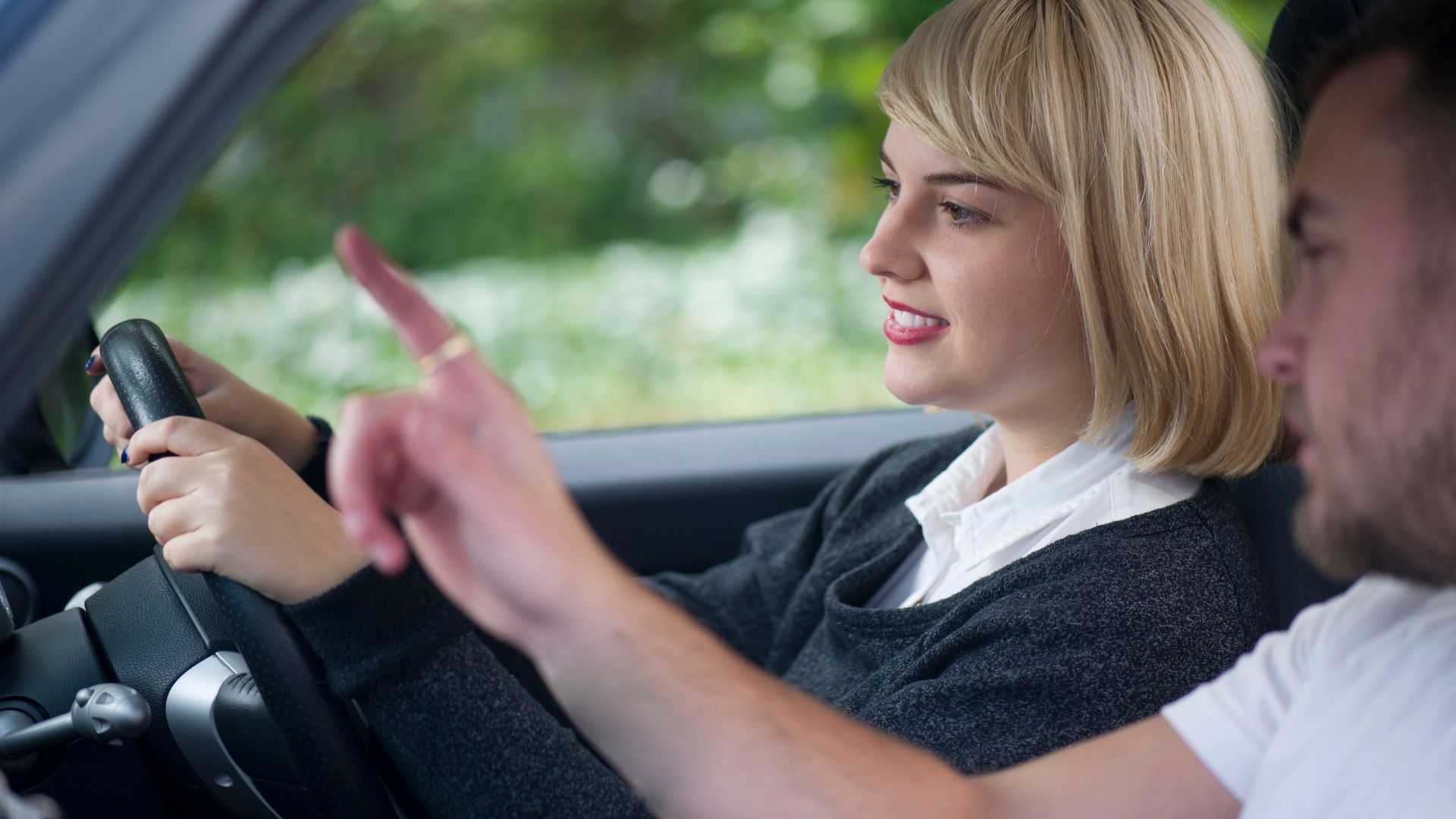 a girl driving car and instructor giving instruction