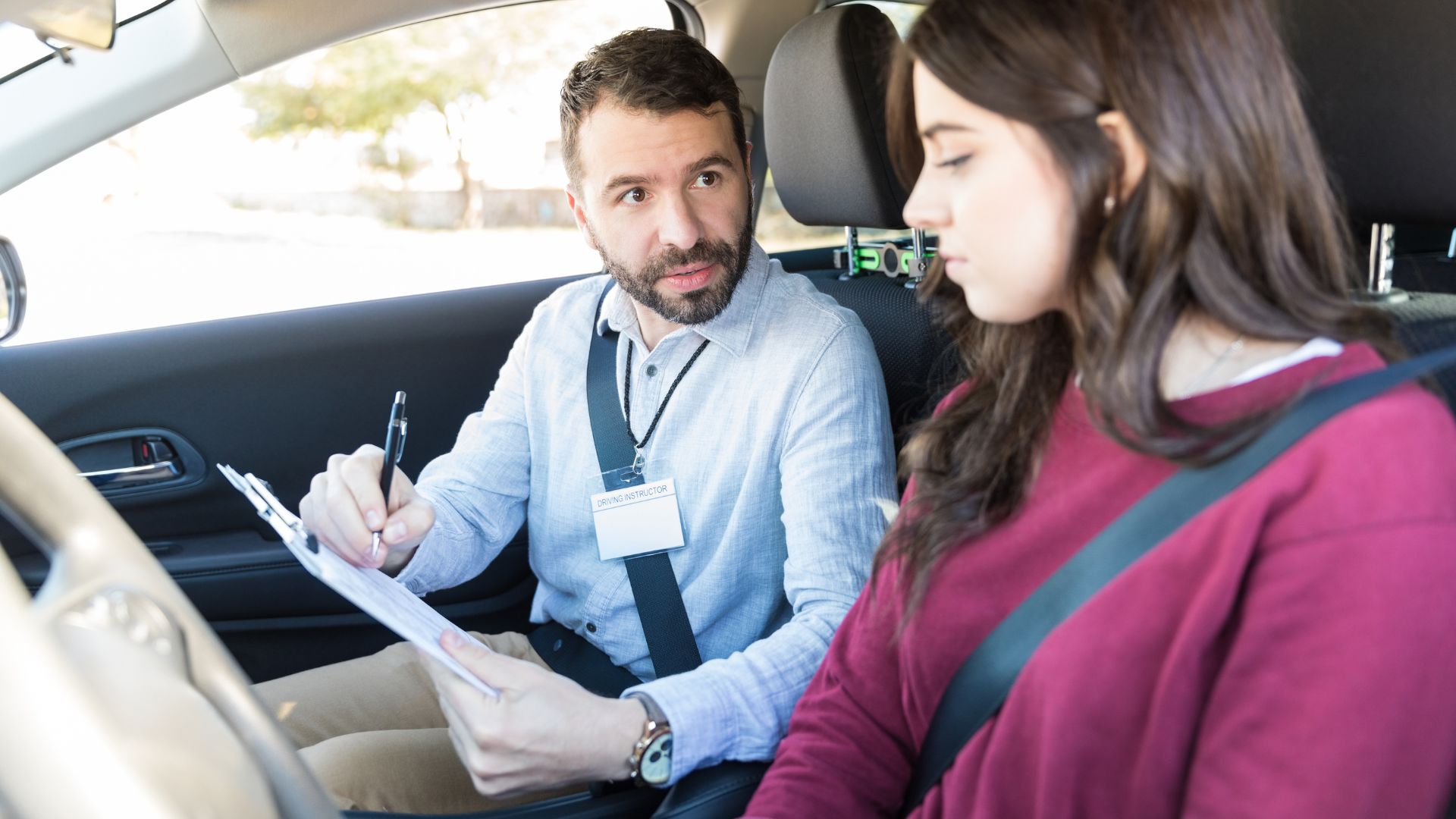 Driving instructor with student in car during lesson.