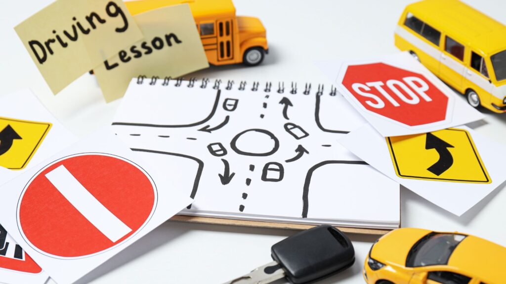 Driving lesson concept with signs and toy vehicles.